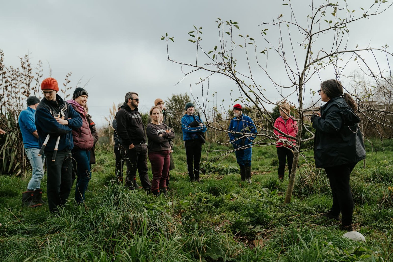 Hannah Dawson sharing grafting and heritage fruit tree tips with a group in the orchard
